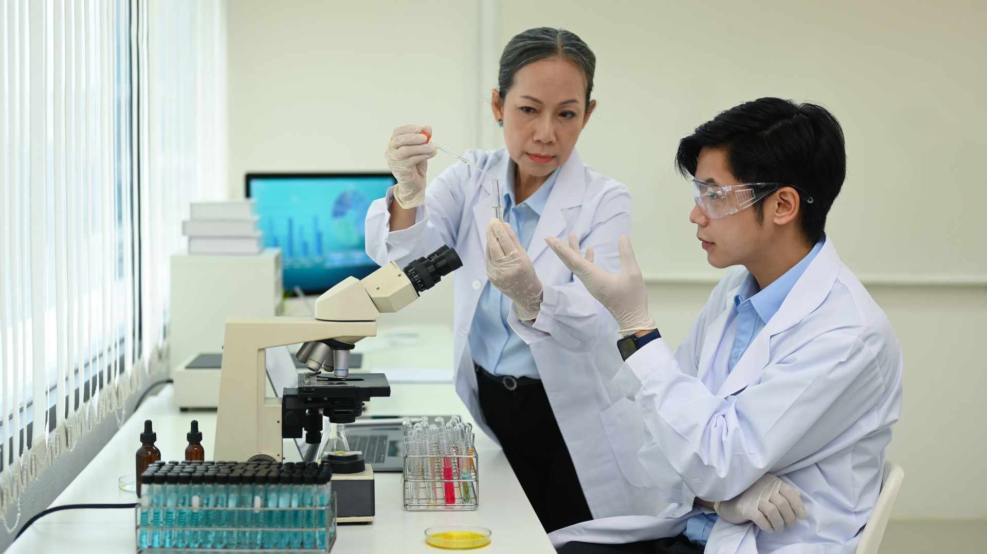 Professional scientists team conducting experiment in modern laboratory. Medicine and science researching concept.