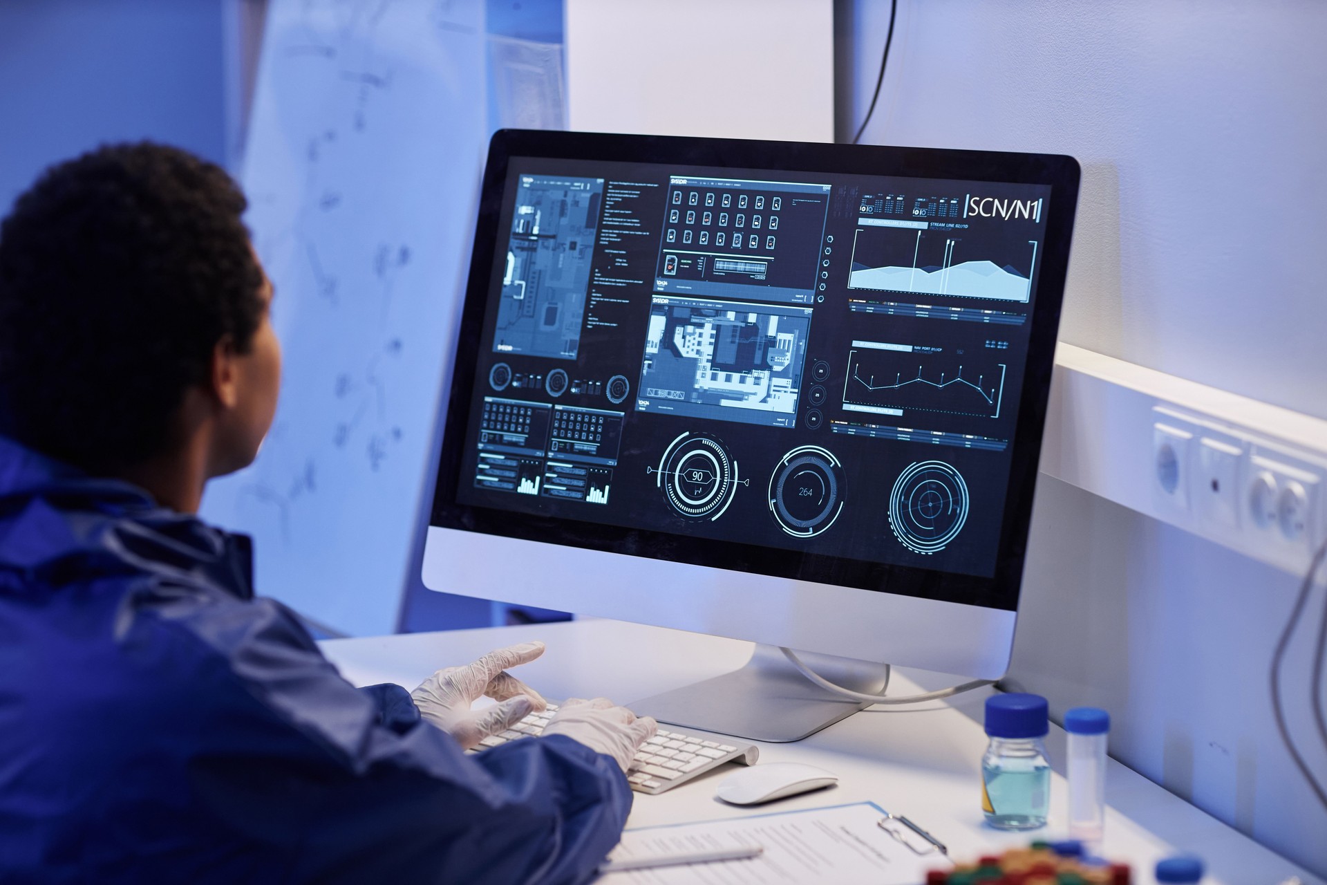 Worker using computer with scientific data in laboratory